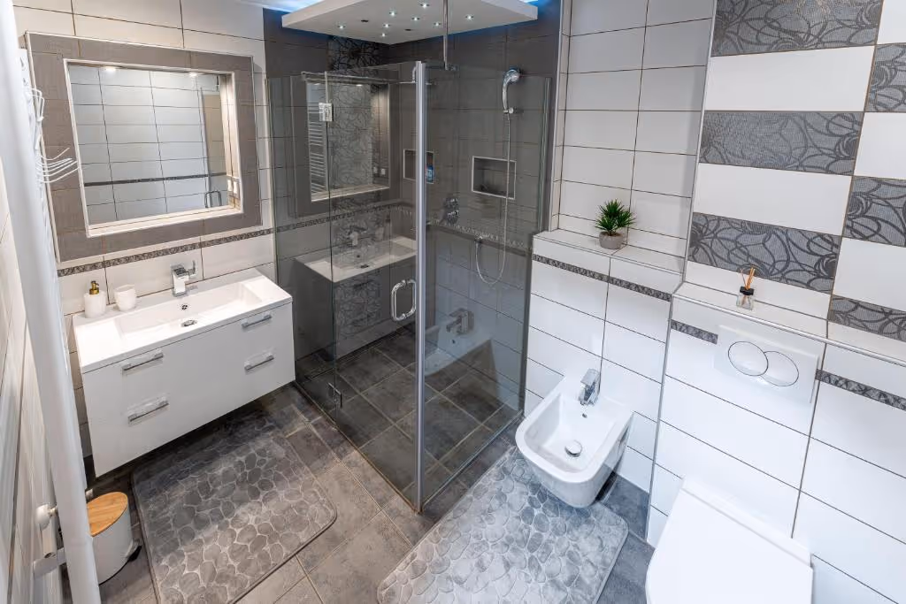 Modern living room with a gray sofa and patterned cushions, a glass coffee table, and travel brochures.